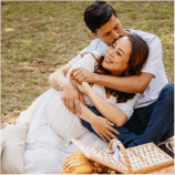 Casal abraçado fazendo piquenique em um parque