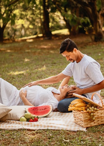 Casal abraçado fazendo piquenique em um parque